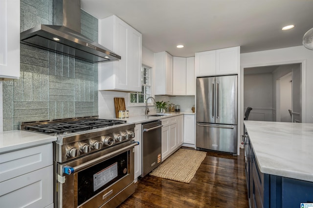 3317 Overton Rd, Mountain Brook, AL 35223 - kitchen featuring stainless steel appliances, wall chimney range hood, a sink, dark wood-type flooring, and white cabinets