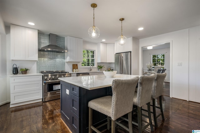 3317 Overton Rd, Mountain Brook, AL 35223 - kitchen with wall chimney exhaust hood, high end appliances, a kitchen breakfast bar, light countertops, and white cabinetry