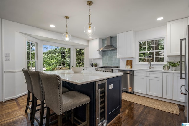 3317 Overton Rd, Mountain Brook, AL 35223 - kitchen with wall chimney range hood, appliances with stainless steel finishes, beverage cooler, a kitchen island, and a sink