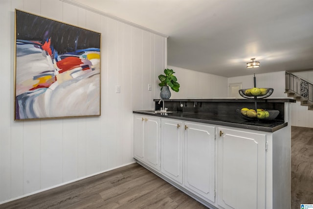 3317 Overton Rd, Mountain Brook, AL 35223 - kitchen featuring wood finished floors, dark countertops, a sink, a peninsula, and white cabinets