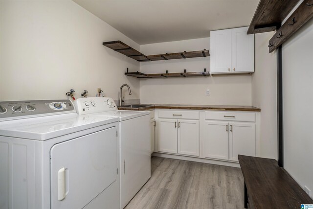 3317 Overton Rd, Mountain Brook, AL 35223 - laundry area featuring light wood-style floors, washing machine and clothes dryer, and cabinet space