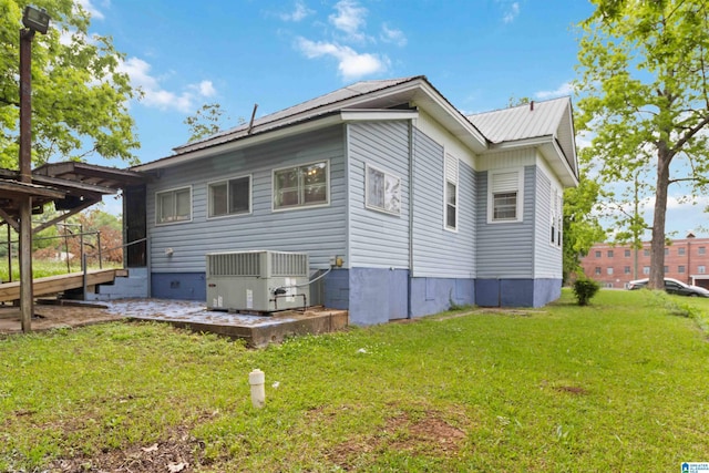 back of house with cooling unit and a yard