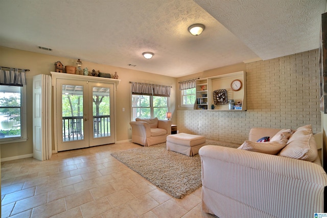 2974 Crescent Crest Dr, Wedowee, AL 36278 - living area featuring baseboards, a textured ceiling, french doors, and brick wall