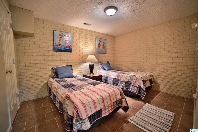 2974 Crescent Crest Dr, Wedowee, AL 36278 - bedroom featuring brick wall, tile patterned floors, and a textured ceiling