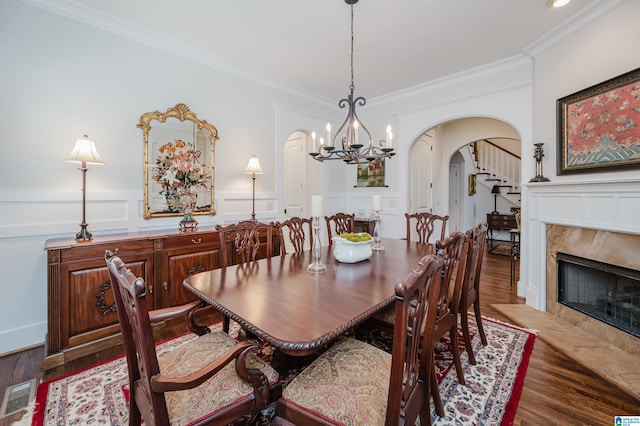 5226 Mountain Ridge Parkway, Birmingham, AL 35222 - dining area featuring arched walkways, wood finished floors, a chandelier, crown molding, and a decorative wall