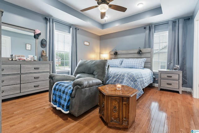 180 Thornberry Dr, Hayden, AL 35079 - bedroom with light wood-type flooring, multiple windows, a raised ceiling, and a ceiling fan