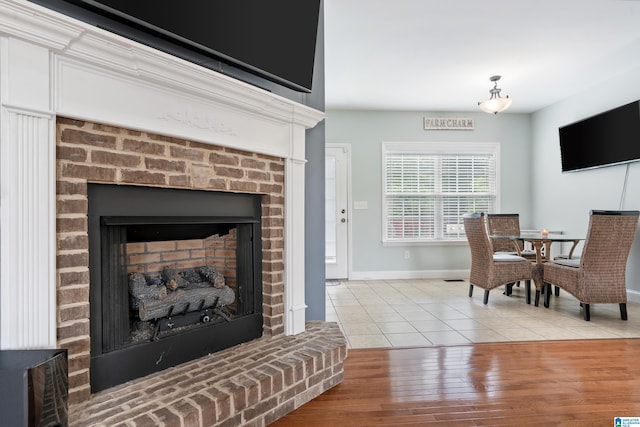 180 Thornberry Dr, Hayden, AL 35079 - living area featuring a brick fireplace, light tile patterned floors, and baseboards