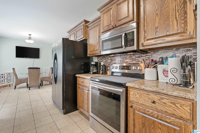 180 Thornberry Dr, Hayden, AL 35079 - kitchen featuring stainless steel appliances, backsplash, light tile patterned floors, and brown cabinets