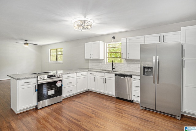 6365 Pocahontas Rd, Bessemer, AL 35022 - kitchen featuring appliances with stainless steel finishes, a peninsula, white cabinetry, and dark wood-style flooring