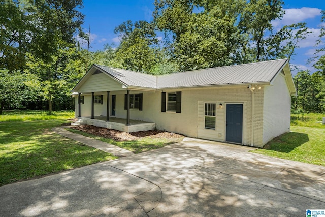 6365 Pocahontas Rd, Bessemer, AL 35022 - ranch-style house featuring a porch, brick siding, a front lawn, a metal roof, and driveway