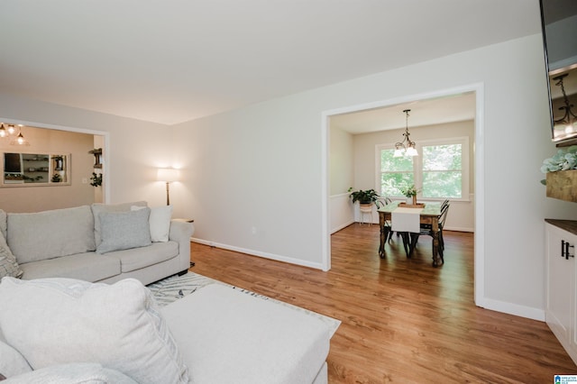 4669 Burning Tree Ln, Pelham, AL 35124 - living room featuring a chandelier, light wood-style flooring, and baseboards