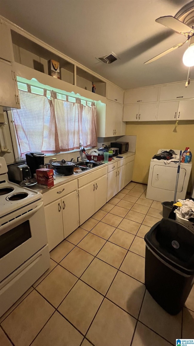 813 W 8th St, Sylacauga, AL 35150 - kitchen featuring white electric stove, washer / dryer, light tile patterned flooring, white cabinets, and light countertops
