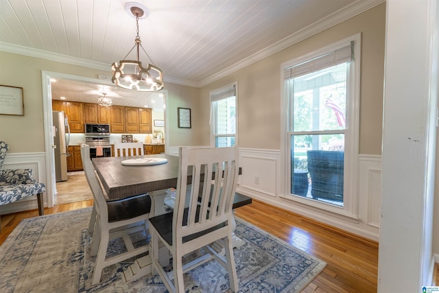 95 River Oaks Ln, Cropwell, AL 35054 - dining area featuring a chandelier, wainscoting, light wood-style flooring, crown molding, and a decorative wall