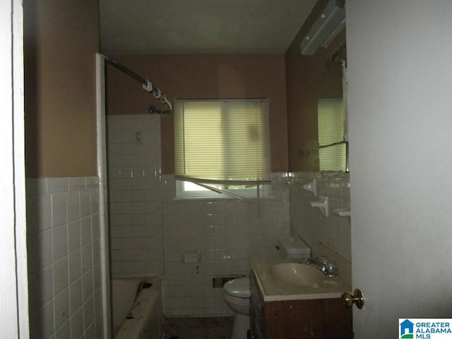 1782 49th St, Birmingham, AL 35208 - bathroom with tile walls, a wall mounted AC, toilet, vanity, and a wainscoted wall