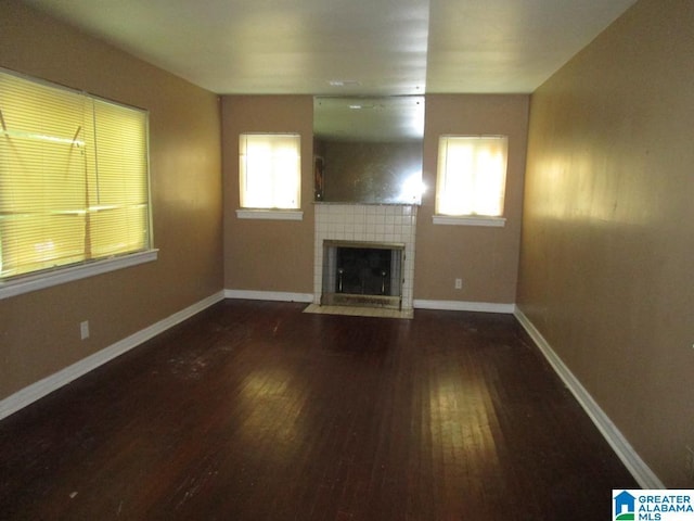 1782 49th St, Birmingham, AL 35208 - unfurnished living room featuring wood finished floors, a tile fireplace, and baseboards