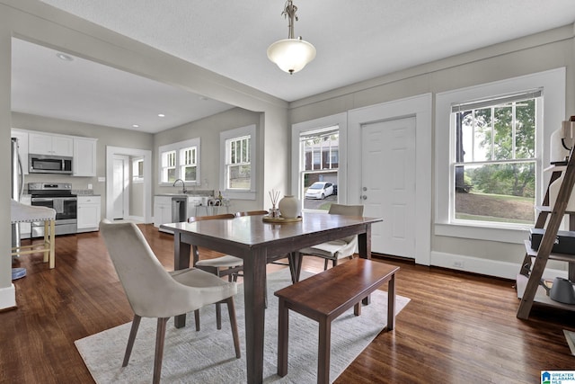 dining space featuring dark wood-style flooring, baseboards, and recessed lighting