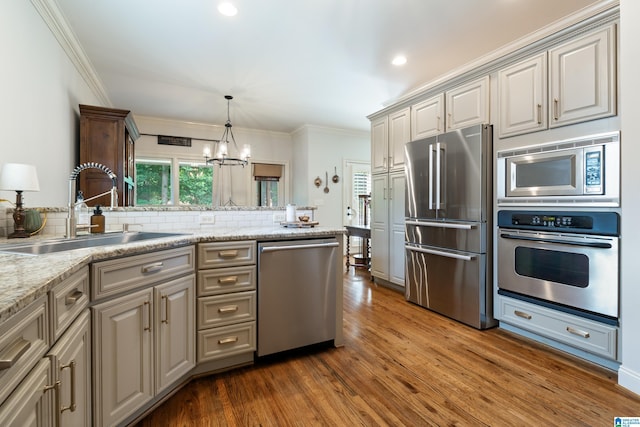 1048 Eagle Hollow Dr, Birmingham, AL 35242 - kitchen featuring appliances with stainless steel finishes, a sink, decorative backsplash, dark wood-type flooring, and a chandelier