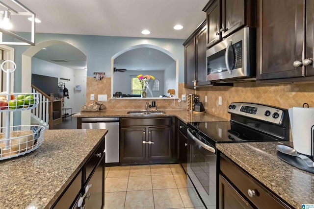 22873 Downing Park Cir, Mccalla, AL 35111 - kitchen featuring stainless steel appliances, a sink, tasteful backsplash, dark stone counters, and arched walkways