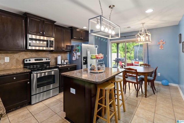 22873 Downing Park Cir, Mccalla, AL 35111 - kitchen with stainless steel appliances, light tile patterned floors, a breakfast bar area, a chandelier, and a kitchen island