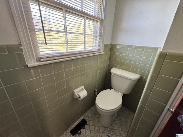 2270 Smithfield Ln N, Birmingham, AL 35207 - bathroom featuring toilet, plenty of natural light, a wainscoted wall, and tile walls