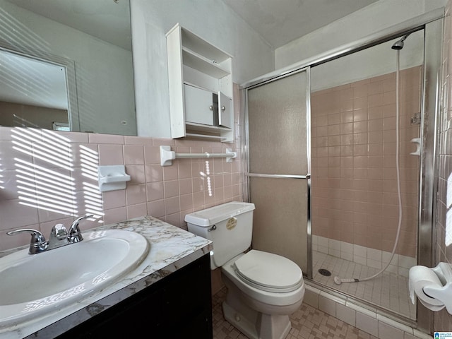 2270 Smithfield Ln N, Birmingham, AL 35207 - bathroom featuring a stall shower, toilet, tile walls, vanity, and tile patterned flooring