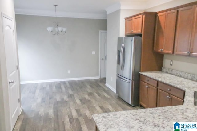 4905 Stonecreek Way, Calera, AL 35040 - kitchen with stainless steel fridge, brown cabinetry, a chandelier, light wood-style floors, and ornamental molding