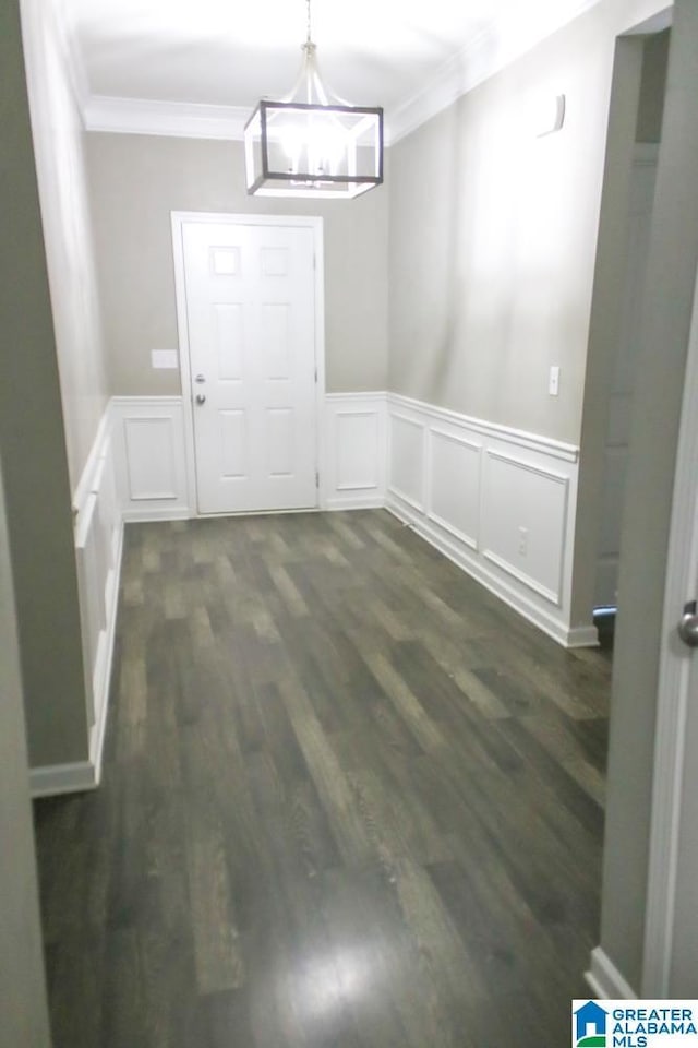 4905 Stonecreek Way, Calera, AL 35040 - unfurnished dining area featuring crown molding, a decorative wall, a chandelier, dark wood-type flooring, and wainscoting