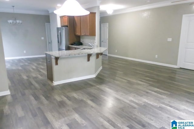 4905 Stonecreek Way, Calera, AL 35040 - kitchen featuring freestanding refrigerator, brown cabinetry, a sink, a chandelier, and crown molding