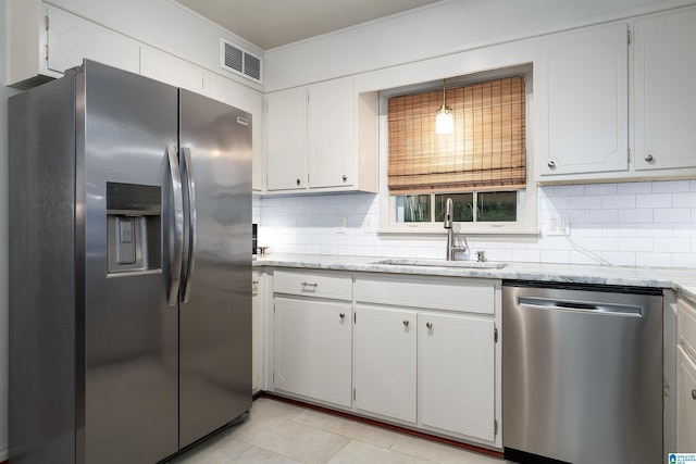 400 Art Hanes Blvd, Birmingham, AL 35213 - kitchen with appliances with stainless steel finishes, a sink, decorative backsplash, light tile patterned floors, and ornamental molding