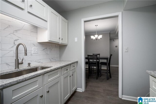 1721 Hackberry Ln Unit 6, Tuscaloosa, AL 35401 - kitchen with tasteful backsplash, white cabinetry, ornamental molding, light stone counters, and dark wood finished floors