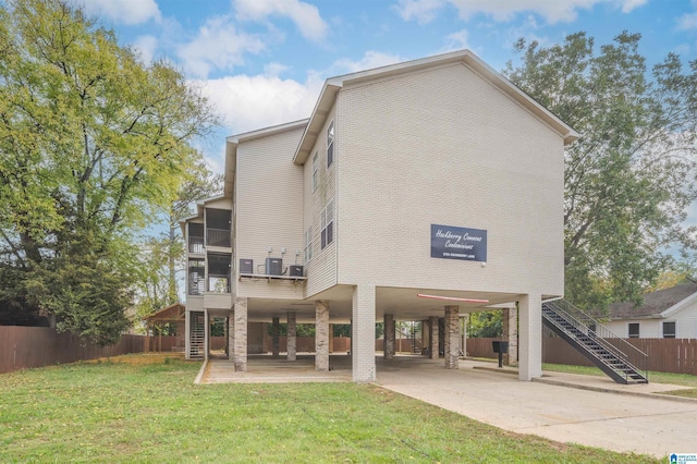 1721 Hackberry Ln Unit 6, Tuscaloosa, AL 35401 - back of property featuring stairway, a carport, a sunroom, and concrete driveway