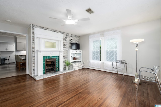 1800 2nd Ave S, Irondale, AL 35210 - unfurnished living room with wood finished floors, ceiling fan, a tiled fireplace, and baseboards