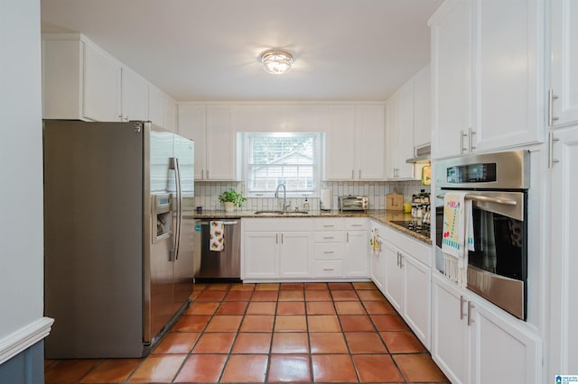 3309 Eaton Rd, Mountain Brook, AL 35223 - kitchen featuring appliances with stainless steel finishes, a sink, backsplash, and white cabinets