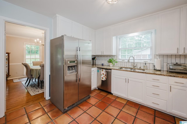 3309 Eaton Rd, Mountain Brook, AL 35223 - kitchen featuring appliances with stainless steel finishes, a sink, a chandelier, decorative backsplash, and crown molding