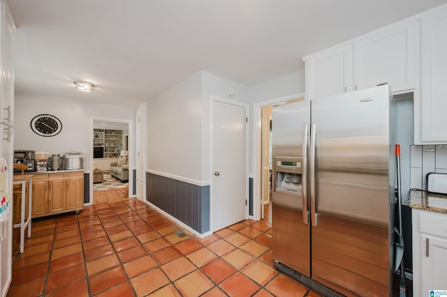 3309 Eaton Rd, Mountain Brook, AL 35223 - kitchen with stainless steel refrigerator with ice dispenser, white cabinetry, light tile patterned floors, a wainscoted wall, and light countertops