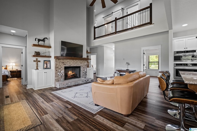 185 Meadowbrook Dr, Piedmont, AL 36272 - living room featuring a ceiling fan, a fireplace, dark wood-style flooring, a high ceiling, and recessed lighting