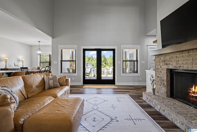185 Meadowbrook Dr, Piedmont, AL 36272 - living area featuring a towering ceiling, baseboards, dark wood-type flooring, and a brick fireplace