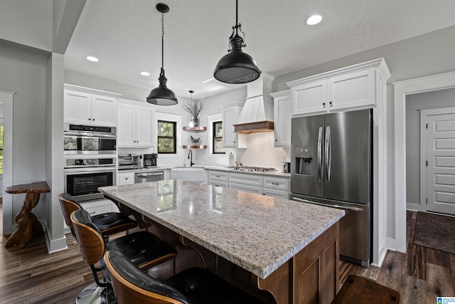 185 Meadowbrook Dr, Piedmont, AL 36272 - kitchen with stainless steel appliances, a sink, premium range hood, a center island, and white cabinetry
