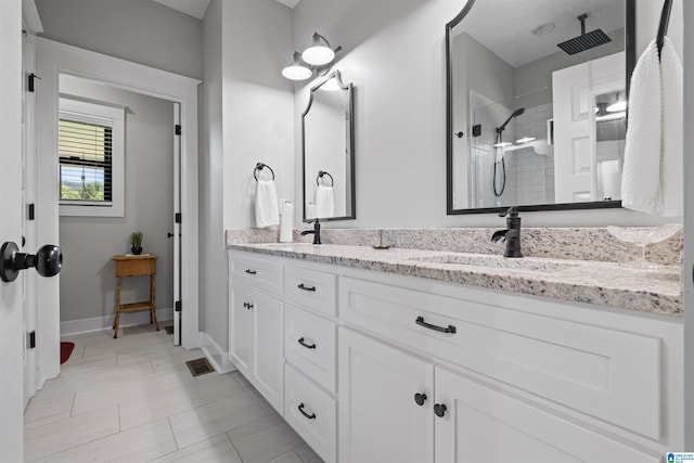185 Meadowbrook Dr, Piedmont, AL 36272 - bathroom featuring double vanity, a tile shower, baseboards, and tile patterned flooring