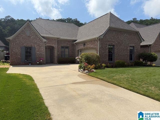 653 Talon Trce, Birmingham, AL 35242 - french country inspired facade with brick siding, driveway, roof with shingles, a front yard, and an attached garage