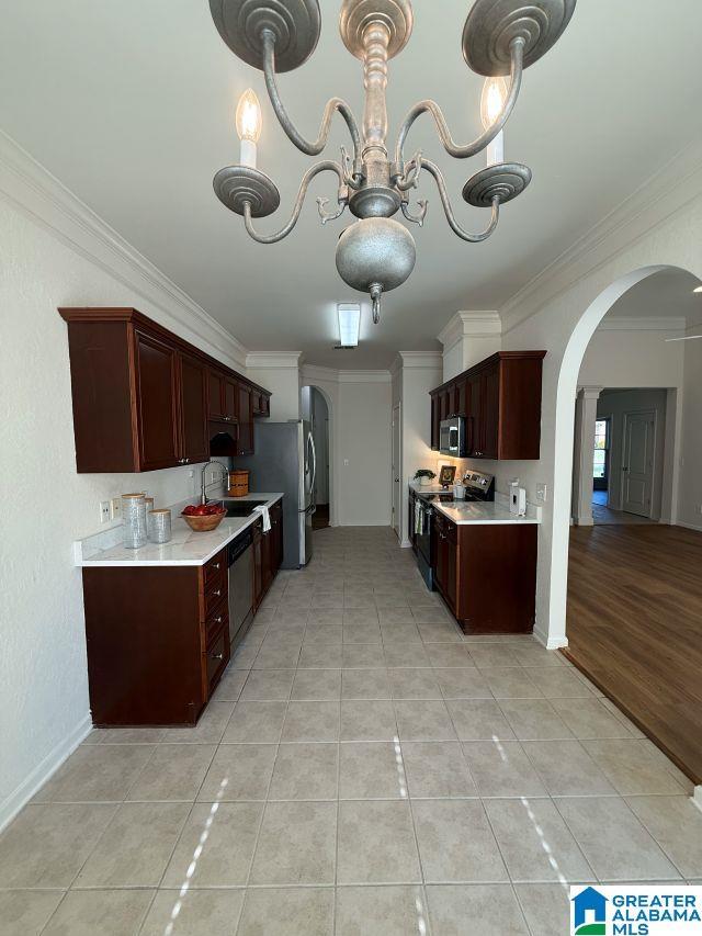 653 Talon Trce, Birmingham, AL 35242 - kitchen with stainless steel appliances, ornamental molding, light countertops, arched walkways, and a sink