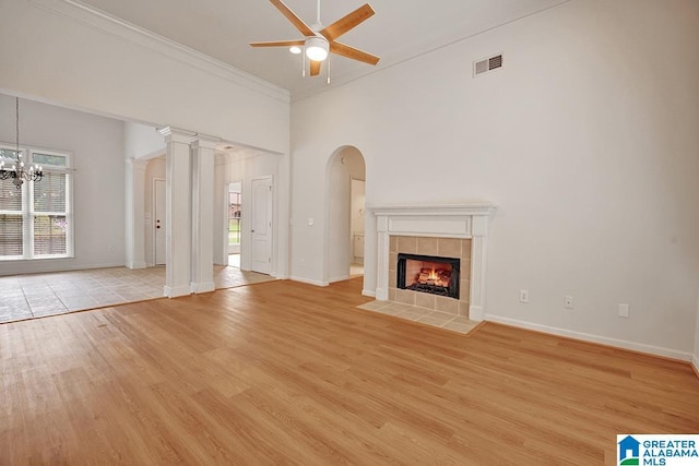 653 Talon Trce, Birmingham, AL 35242 - unfurnished living room with a ceiling fan, light wood-style floors, ornamental molding, a tile fireplace, and a chandelier