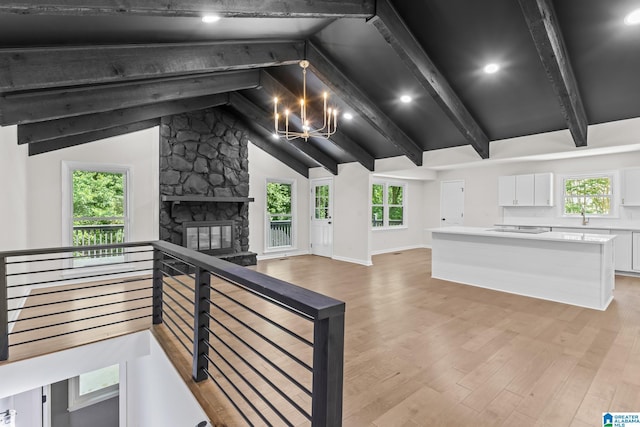 1608 Kestwick Dr, Hoover, AL 35226 - unfurnished living room featuring a chandelier, light wood finished floors, a sink, a stone fireplace, and healthy amount of natural light