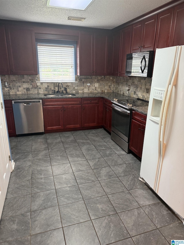 18470 Whispering Meadows Blvd, Vance, AL 35490 - kitchen with appliances with stainless steel finishes, a sink, reddish brown cabinets, tasteful backsplash, and a textured ceiling