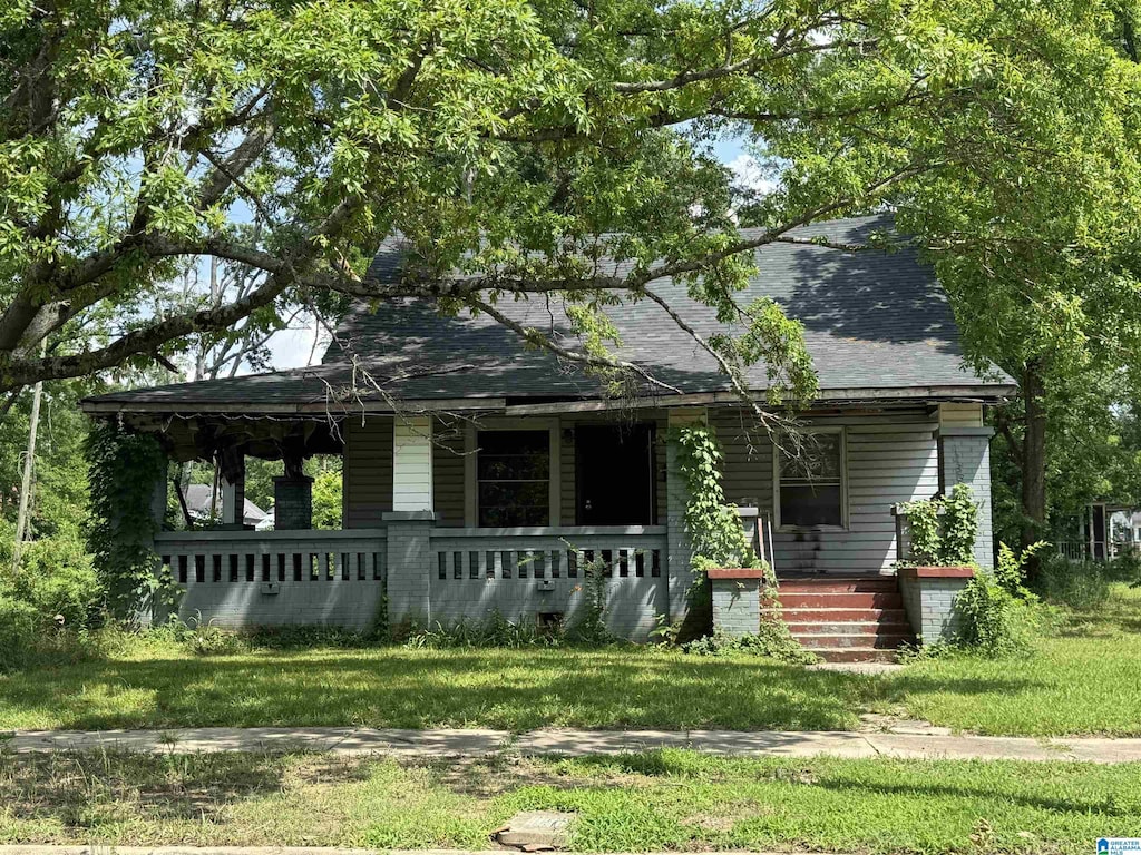 7405 N 4th Ave, Birmingham, AL 35206 - view of front facade featuring covered porch, a shingled roof, and a front yard