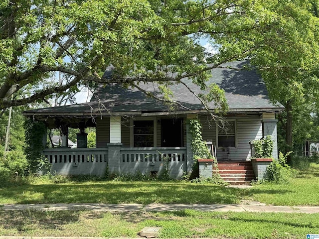 7405 N 4th Ave, Birmingham, AL 35206 - view of front facade featuring covered porch, a shingled roof, and a front yard