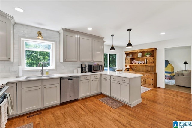 113 Pine Cliff Cir, Hoover, AL 35226 - kitchen with appliances with stainless steel finishes, a sink, a peninsula, light wood-style floors, and backsplash