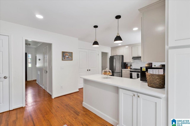 113 Pine Cliff Cir, Hoover, AL 35226 - kitchen with appliances with stainless steel finishes, under cabinet range hood, a peninsula, wood finished floors, and pendant lighting