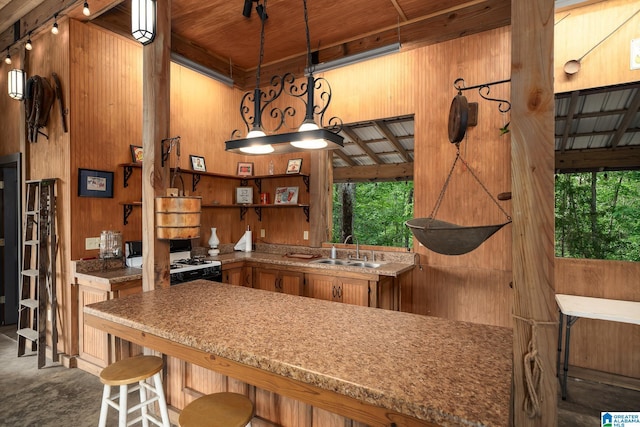295 Ridge View Way, Springville, AL 35146 - kitchen featuring a sink, white gas stove, open shelves, wooden walls, and brown cabinets