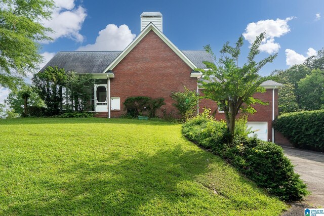 295 Ridge View Way, Springville, AL 35146 - view of property exterior featuring brick siding, a lawn, a chimney, and a garage